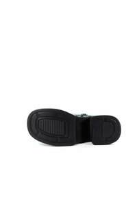 Czarna kauczukowa podeszwa z teksturowanymi rowkami, o płaskim designie. Wierzch w kolorze zielonym z zamkiem błyskawicznym. Brak widocznych logo lub akcentów.