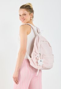 Pink and white striped backpack with a front pocket, fabric material, adjustable straps, and a white teddy bear keychain.