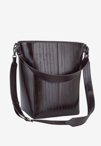 Brun skuldertaske i læder med en struktureret form, glat tekstur og lodrette striber. Har en justerbar rem for alsidighed.