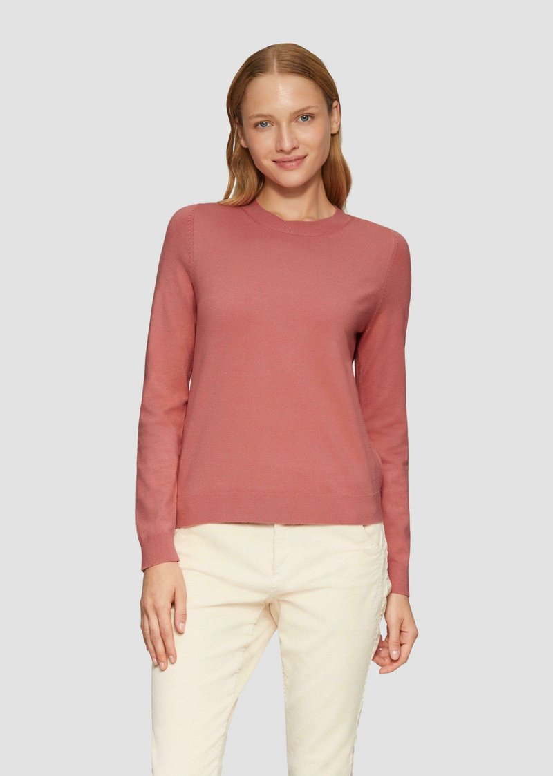 Rosa langärmliger Pullover mit Rundhalsausschnitt, gerippten Bündchen und Saum, mit einer glatten, strukturierten Oberfläche. Getragen mit hellen Hosen.