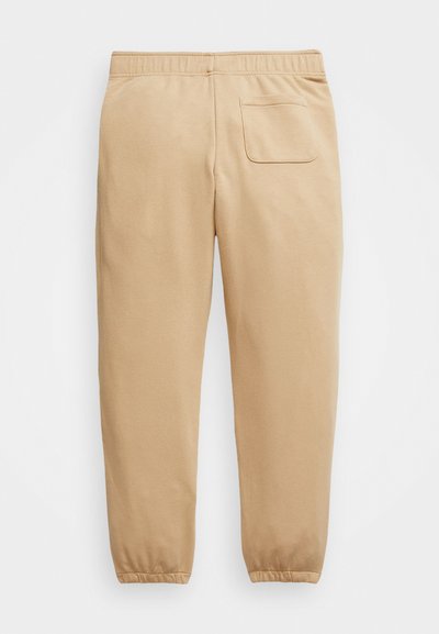 Pantalones de chándal beige con una cintura elástica, puños elásticos y un solo bolsillo trasero. Tejido suave, corte relajado y perneras ajustadas.