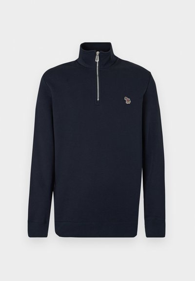 Μπλε σκούρο μακρυμάνικο πουλόβερ με ψηλό γιακά, ασημένιο φερμουάρ μπροστά και μικρό πολύχρωμο λογότυπο ζέβρας στο αριστερό στήθος.