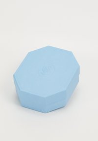 Oktagonal æske i lyseblåt papir med en struktureret overflade. Har et forhøjet emblem på låget. Glatte kanter og robust design.