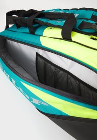 Mehrfachfächer-Sporttasche aus einer Kombination von Türkis und Neongelb, mit stabilen schwarzen Trägern und einer Netztasche zur besseren Organisation.