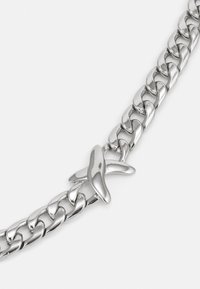 Bracelet en argent composé de grosses mailles entrelacées et d'un fermoir en forme de papillon poli. Texture lisse avec une finition métallique.