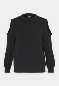 Sudadera negra con cortes en los hombros, mangas largas abullonadas, puños acanalados y un sutil logotipo bordado en el pecho.