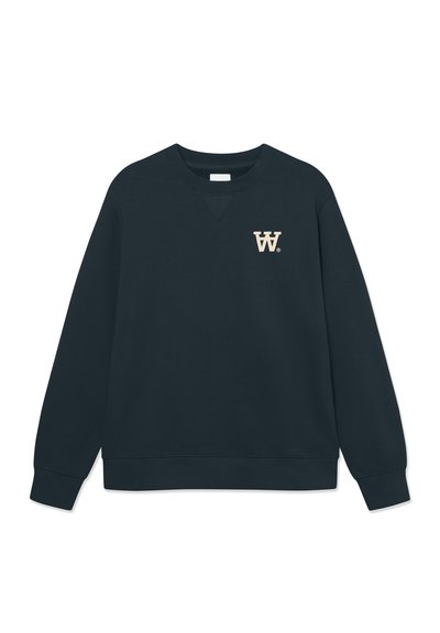 Sweatshirt bleu marine foncé en tissu doux, avec un col rond, des manches longues et un petit logo "W." beige sur la poitrine gauche.