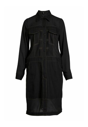 Juoda ilgomis rankovėmis, kelio ilgio suknelė su priekiniais užsegamais mygtukais, apykakle, krūtinės kišenėmis su atvartais ir kontrastingomis oranžinėmis siūlėmis.