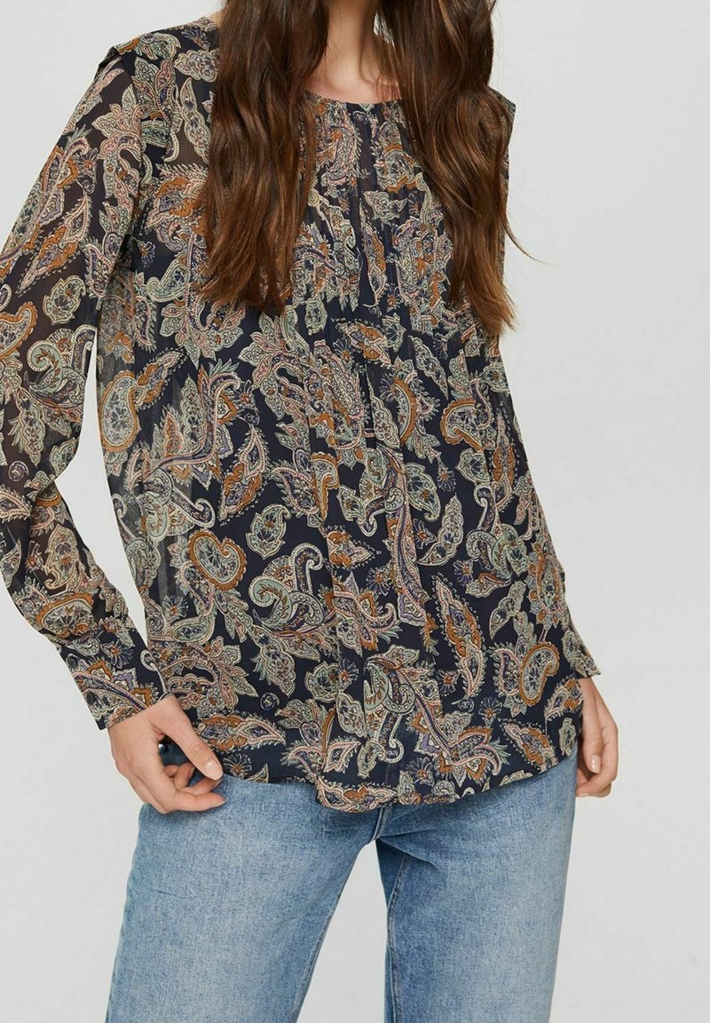 Blusa a maniche lunghe di un blu navy scuro con intricate fantasie paisley in tonalità di verde e arancione. Tessuto leggero e fluido con dettagli arricciati.