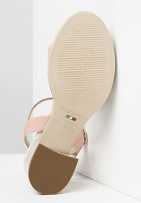 Sandal in pelle rosa con suola beige caratterizzata da una superficie testurizzata. Dettagli in metallo dorato e branding sulla suola, misura 37.