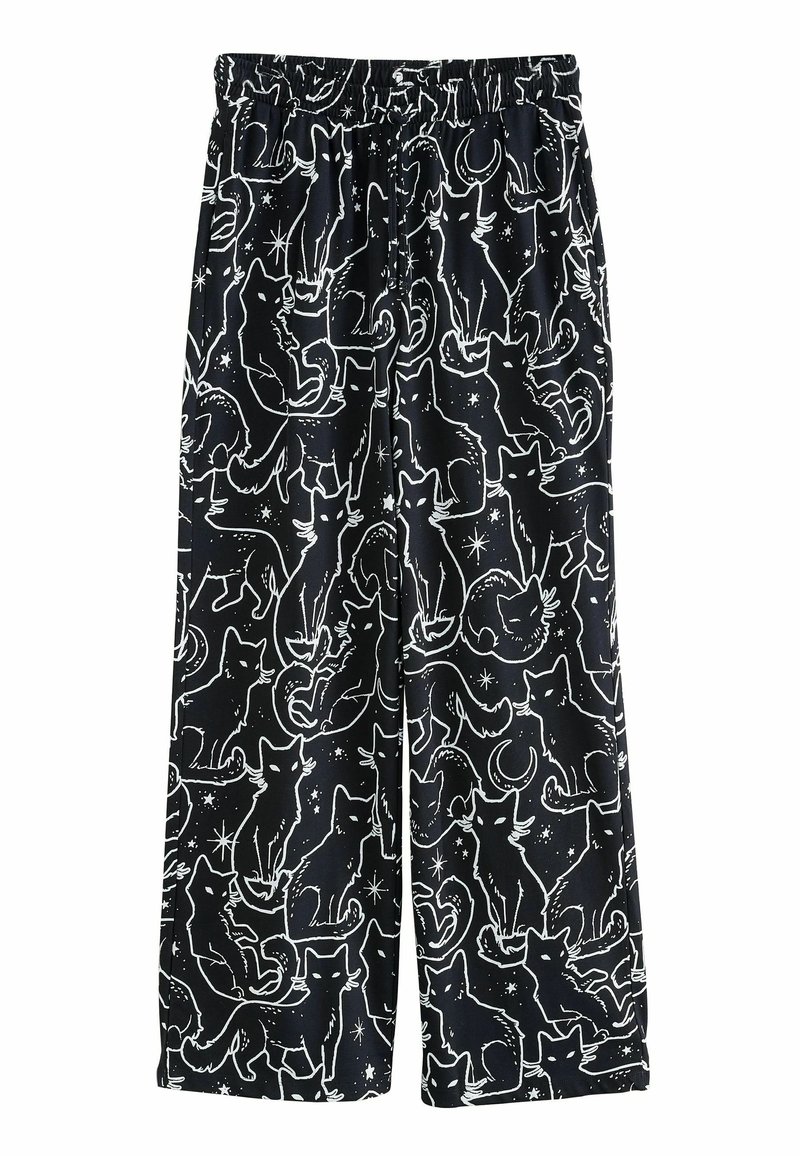 Pantalones de pijama negros con cintura elástica, que presentan un patrón de un gato blanco y elementos celestiales, incluyendo estrellas y lunas. Diseño suelto y de pierna ancha.