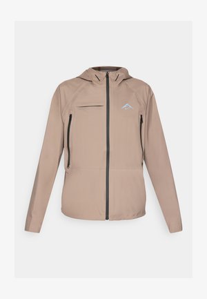 Lett beige jakke med en tilpasset hette, glidelåsåpning og lommer, samt subtil logoakcent. Glatt stoff med teksturerte detaljer.