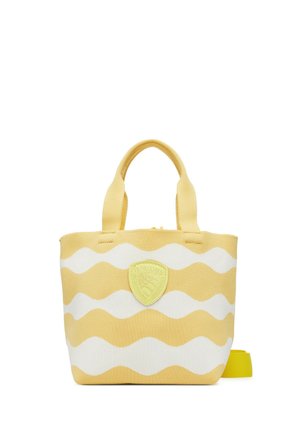 Piccola borsa tote a righe gialle e bianche con due manici e una toppa logo gialla sulla parte anteriore, mostrata su uno sfondo bianco.