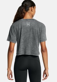 Korte grijze t-shirt gemaakt van zachte stof met korte mouwen en een ronde hals. Heeft een logo in het wit op de bovenrug.