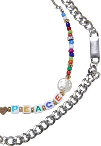 Färgglad pärlhalsband med bokstäver som stavar "PEACE", en pärlaccent och en silverkedja. Pärlorna har olika former och färger.