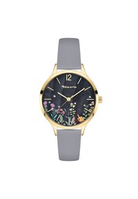 Goldfarbene Uhr mit grauem Silikonarmband, dunkel floral gemustertem Zifferblatt, goldenen Stundenmarkierungen und dem markierten Markennamen "Tamaris".
