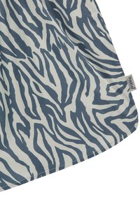 Zebra-mønstrede stoffer i nuancer af blå og hvid med en glat tekstur. Har en syet kant og et synligt mærkelabel på kanten.