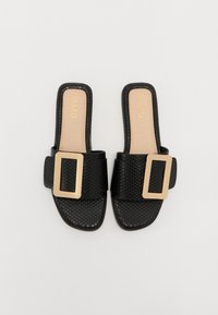 Sandales noires à glissière avec une tige synthétique texturée, large lanière avec une boucle rectangulaire dorée et une semelle plate.