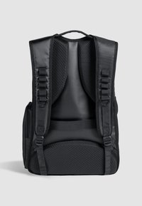 Mochila negra con respaldo de malla acolchada, correas ajustables y un exterior liso. Cuenta con un asa en la parte superior y un bolsillo con cremallera en el lateral.