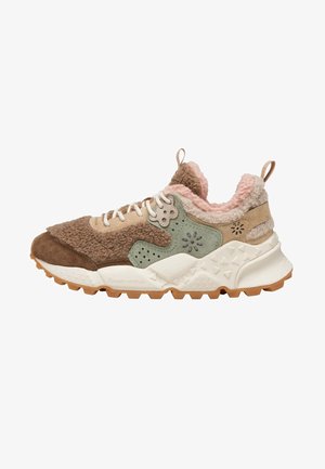 Niski sneaker z brązowym i beżowym kożuchem, zielonymi zamszowymi akcentami, białą masywną podeszwą z geometrycznymi wzorami i białymi sznurowadłami.