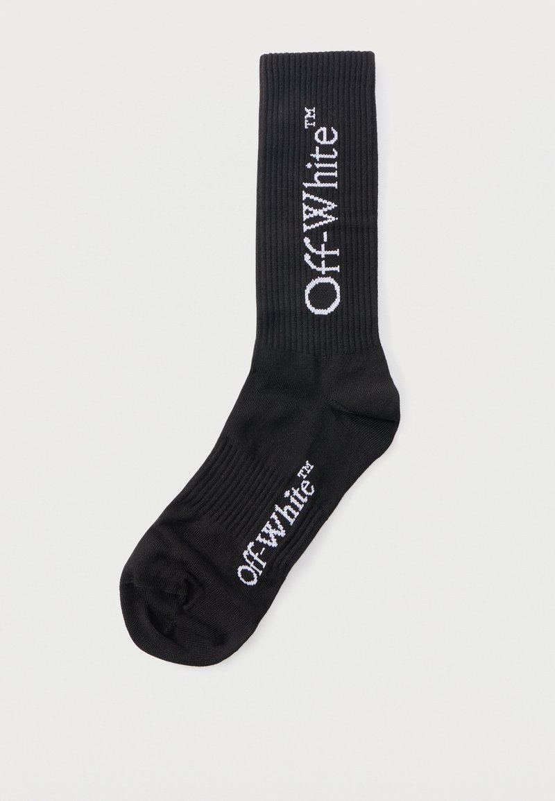 Chaussette noire côtelée avec le logo "Off-White™" blanc sur le bord et le pied, présentée à plat sur un fond blanc.