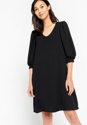 Black dress with a V-neck, puff sleeves, and a loose, A-line silhouette, made from lightweight fabric with a subtle texture.