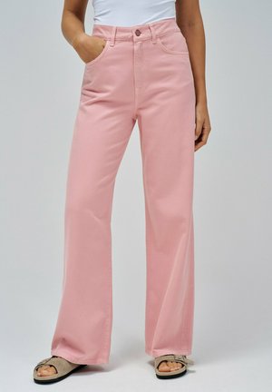 Pantalones de mezclilla rosa de pierna ancha con cintura alta, que presentan bolsillos delanteros y cierre de botón, combinados con sandalias beiges.