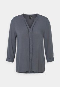 Mörkgrå blus med v-ringad hals, knapprad framtill och 3/4 ärmar. Har dekorativ sömnad längs placket och ärmsluten. Slät textur.