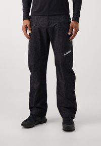 Μαύρο παντελόνι εξωτερικού χώρου με σχέδιο και φερμουάρ στις τσέπες. Κατασκευασμένο από ελαφρύ, υφασμάτινο υλικό. Διαθέτει ένα έντονο λογότυπο Terrex στο πλάι.