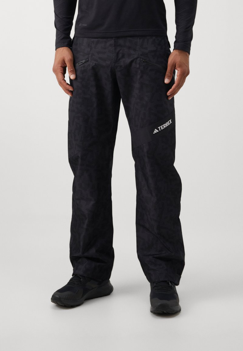 Μαύρο παντελόνι εξωτε�ρικού χώρου με σχέδιο και φερμουάρ στις τσέπες. Κατασκευασμένο από ελαφρύ, υφασμάτινο υλικό. Διαθέτει ένα έντονο λογότυπο Terrex στο πλάι.