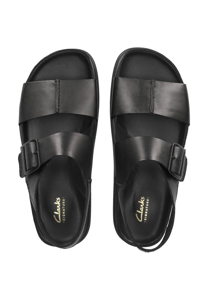 Sandali neri in pelle con due larghe cinghie e una fibbia regolabile. Presentano una suola imbottita e un logo dorato sulla soletta.