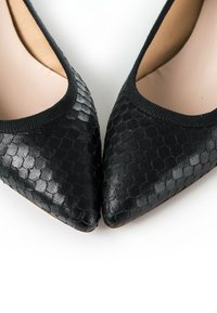 Pumps nere a punta con un motivo texturizzato in pelle di serpente sulla parte superiore, dotate di una soffice fodera beige e un bordo elasticizzato nero.