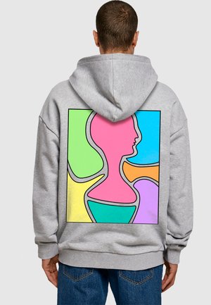 Grå hættetrøje med en multicolor abstrakt design på ryggen, med former omridset i sort. Teksturert stof, løs pasform.