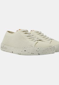 Beige Mesh-Sneaker mit weißen gesprenkelten Gummisohlen und traditionellem Schnürdesign. Texturiertes Obermaterial mit leichtem Belüftungsmuster.
