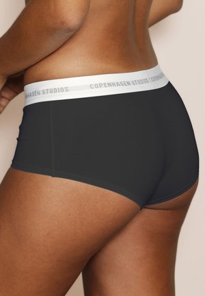 Schwarze Stretch-Shorts mit einem weißen Bund, der mit "Copenhagen Studios" beschriftet ist, mit einer glatten Textur und figurbetontem Schnitt.
