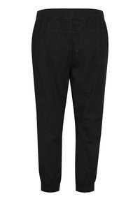 Mustat nilkkapituudet housut, joissa on joustava vyötärö ja hihnattomat lahkeet. Valmistettu sileästä kankaasta, muotoilu sisältää minimaalisen sauman ja ilman taskuja.