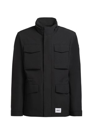 Giacca nera con colletto alto, quattro tasche frontali e un'etichetta visibile. Realizzata in un tessuto liscio con un design minimalista.