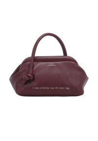 Borsa a mano in pelle color bordeaux con forma arrotondata, manici superiori e un dettaglio annodato. Sul davanti è scritto: "Ero una bottiglia, ora sono la tua borsa."