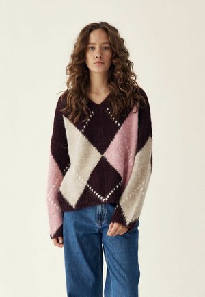 V-veida džemperis, izgatavots no mīkstas vilnas maisījuma, ar dimanta rakstu bordo, rozā un krēmkrāsā. Brīva piegriezuma, ar ribotām apakšmalām un garām piedurknēm.