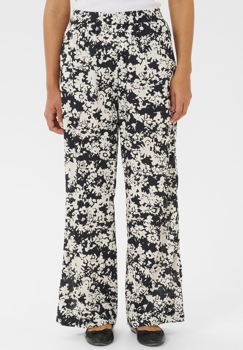 Pantalons larges à fleurs en tissu noir et blanc. Caractéristiques : taille élastique et coupe ample. Imprimé floral couvrant toute la surface.