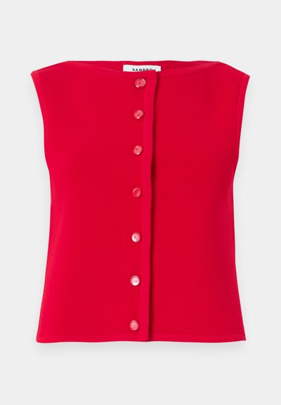 Κόκκινο αμάνικο τοπ φτιαγμένο από ριμπ ύφασμα, με κουμπιά σε ροζ απόχρωση στον μπροστινό μέρος. Ευθεία φάσα και στρογγυλή λαιμόκοψη.