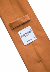 Oranssiraidallinen solmio, jossa on sileä pinta, ja johon kuuluu kangassilmukka sekä valkoinen etiketti, jossa lukee "JOHN HENRIC, RUOTSI, Valmistettu Italiassa."