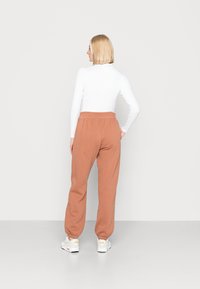 Nike Sportswear W NSW ESSNTL PANT FLC TREND - Calças de fato de treino - mineral clay/white