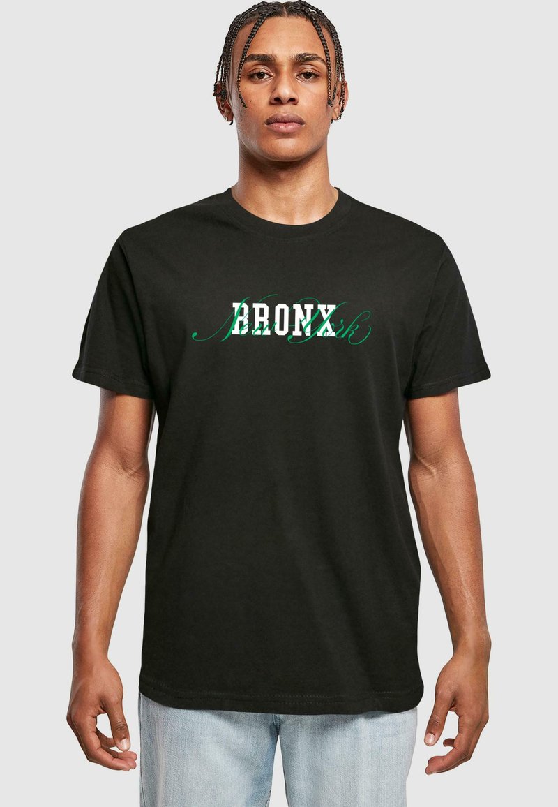 Sort bomuld t-shirt med "BRONX" i hvid og grøn stiliseret tekst, korte ærmer, rund halsudskæring og afslappet pasform.