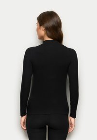 Schwarzes Langarmoberteil mit Rundhalsausschnitt, aus einem glatten, dehnbaren Stoff gefertigt. Figurbetonte Silhouette, der Saum sitzt auf Hüfthöhe.