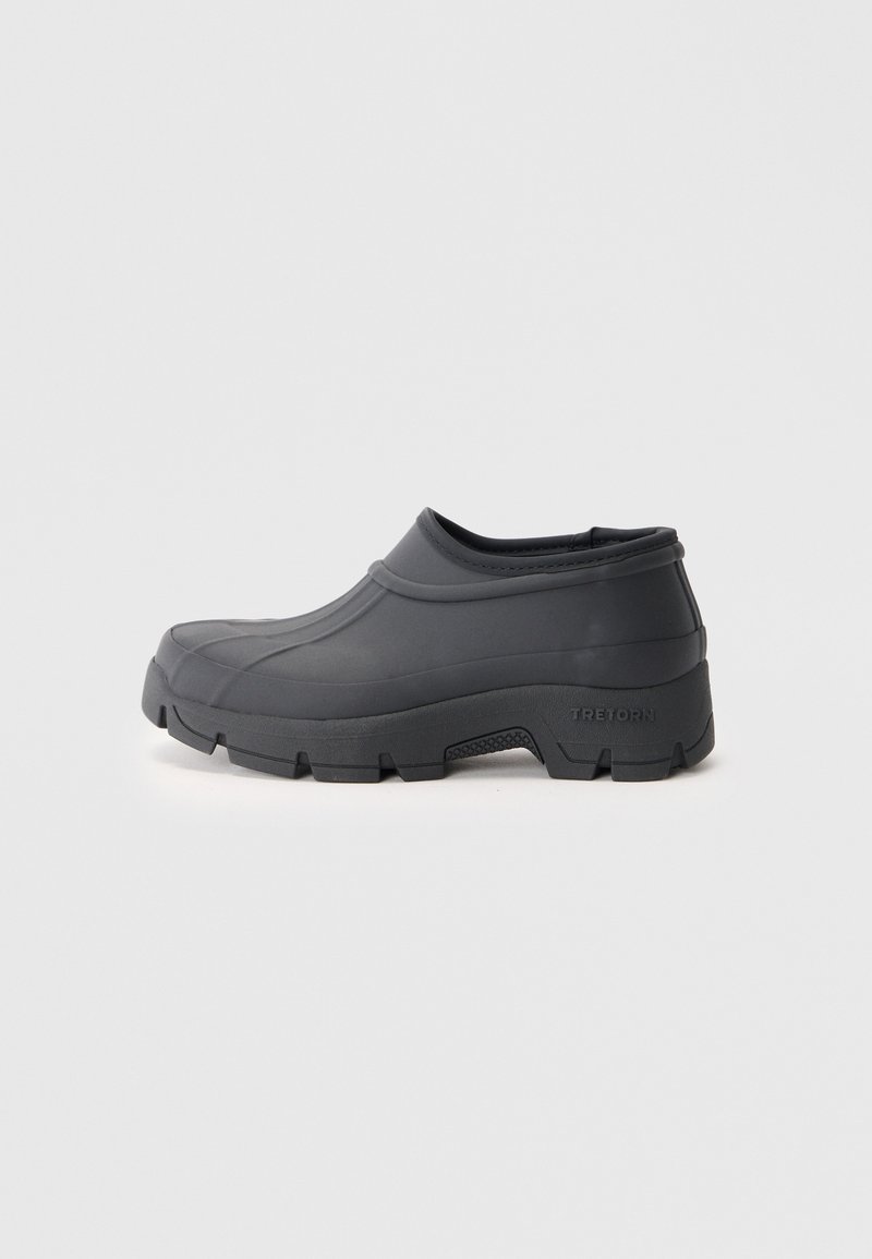 Black rubber slip-on shoes with a rounded toe and textured sole, featuring a smooth upper and a raised edge around the opening.
