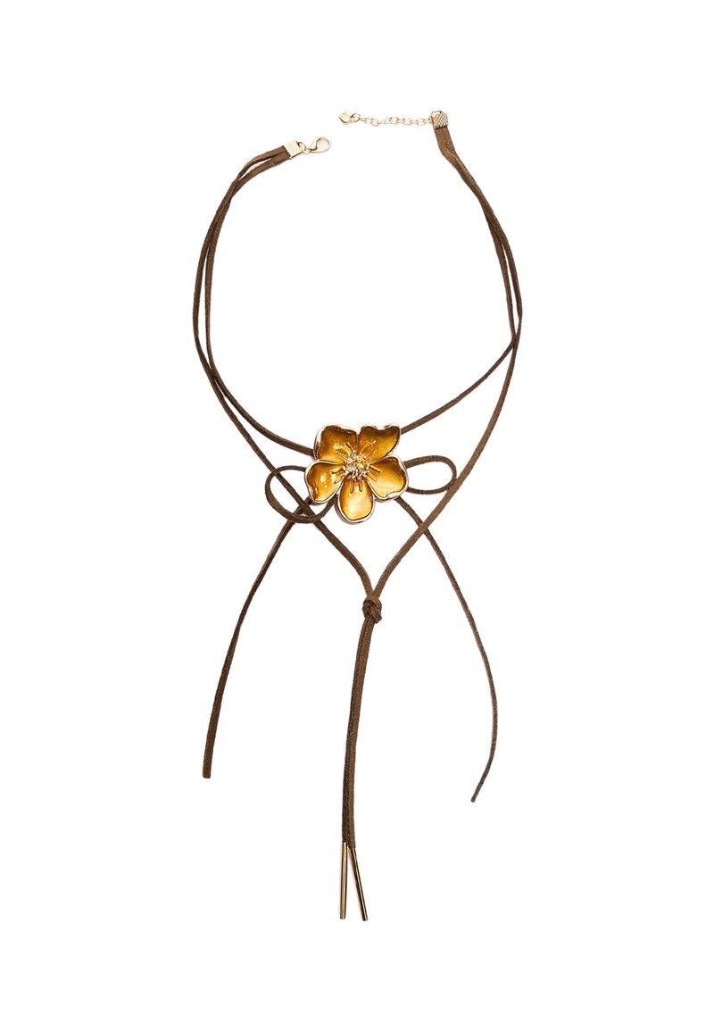 Brauner Wildleder-Choker mit einem zentralen goldenen Blumenakzent und zwei langen Bändern, die nach unten hängen. Verfügt über einen Verschluss und eine verstellbare Kette.