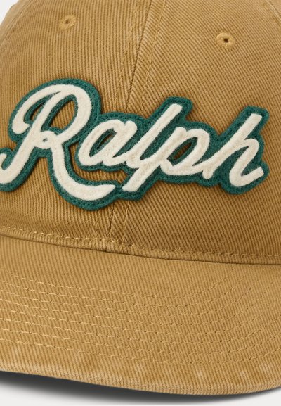 Világosbarna baseball sapka zöld-fehér hímzett címkével, amelyen a "Ralph" név írott betűkkel szerepel az elején.