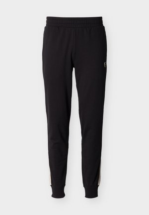 Zwarte slim-fit joggerbroek met een elastische tailleband en boorden, voorzien van beige zijstrepen en een klein logo op de bovenkant van de dij.