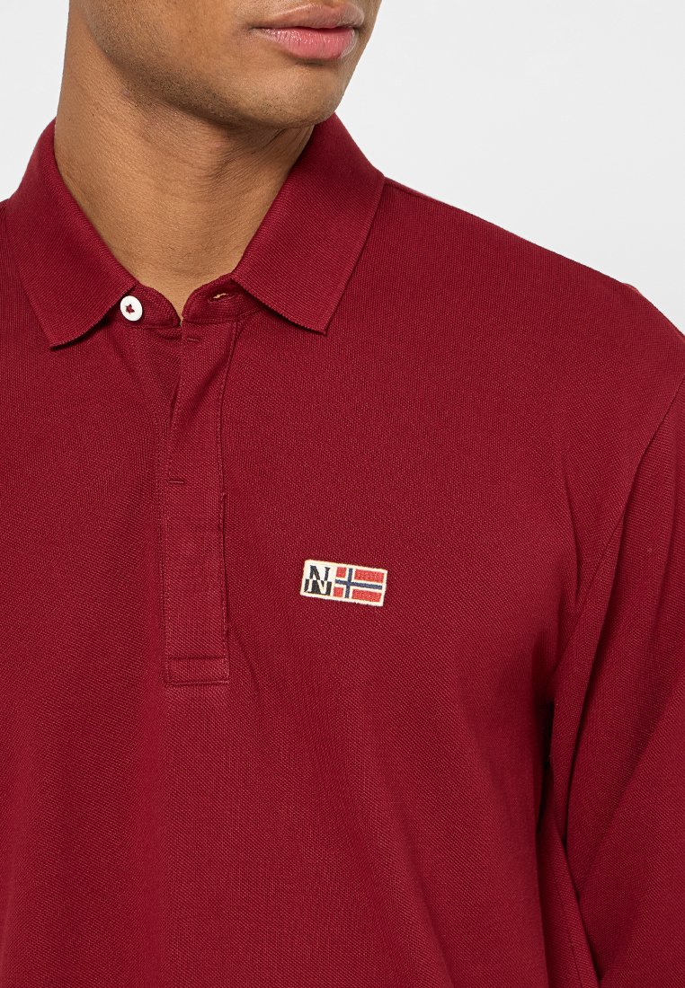 Bordowa koszulka polo z teksturowanej tkaniny, z klasycznym kołnierzykiem i małym, haftowanym logo na piersi. Zapięcie na dwa guziki.